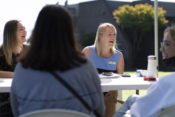 Houseparents smiling while talking to a family