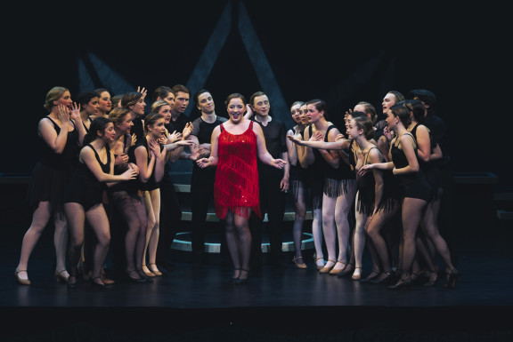 A group of students performing in the Musical Chicago