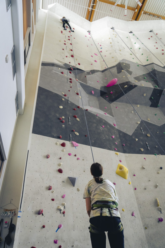 A student holding the top rope for a climber