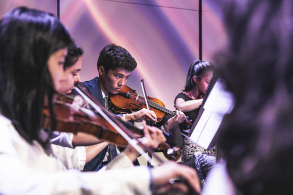 A student playing violin on stage