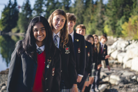 Students smiling while in uniform outside