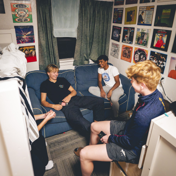 Four boys chatting comfortably in their dorm room