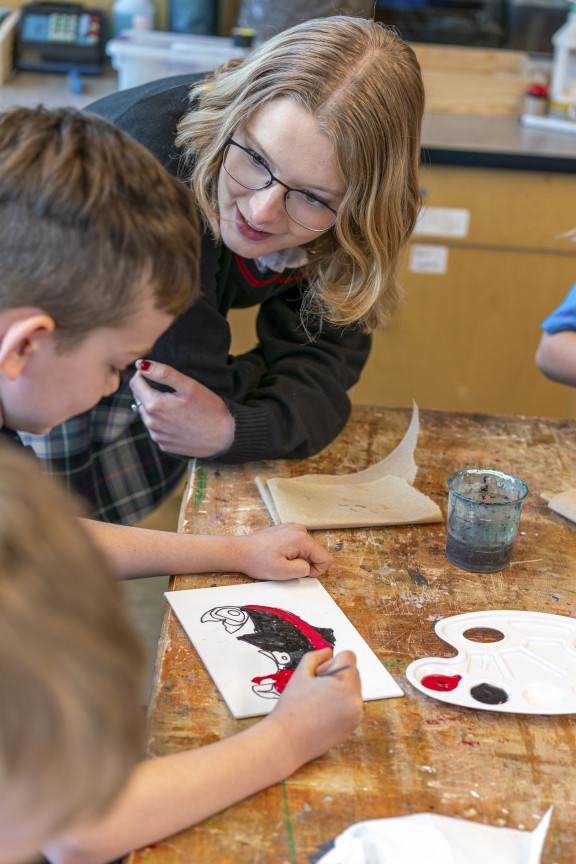 A student speaking with a younger child