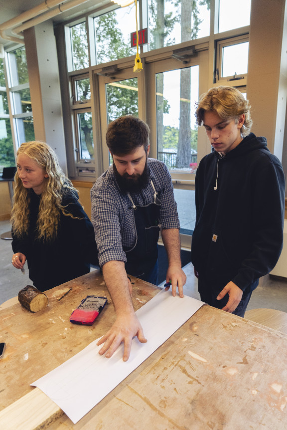 A teacher working with sculpture students