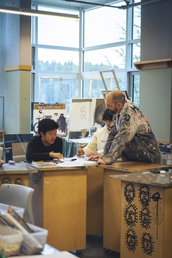 A teacher working with students in the studio