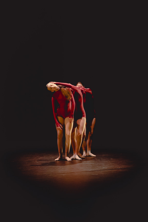 A group of dancers in red bodysuits
