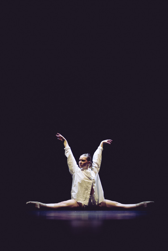 A dancer doing the splits on stage