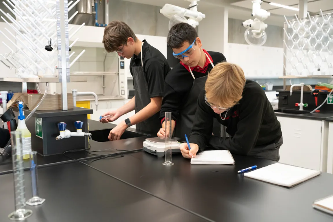 three private school academic students in chemistry lab