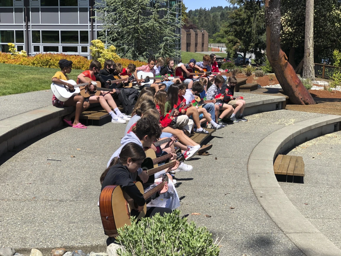 Students eating lunch on the terraced campus steps on a sunny day