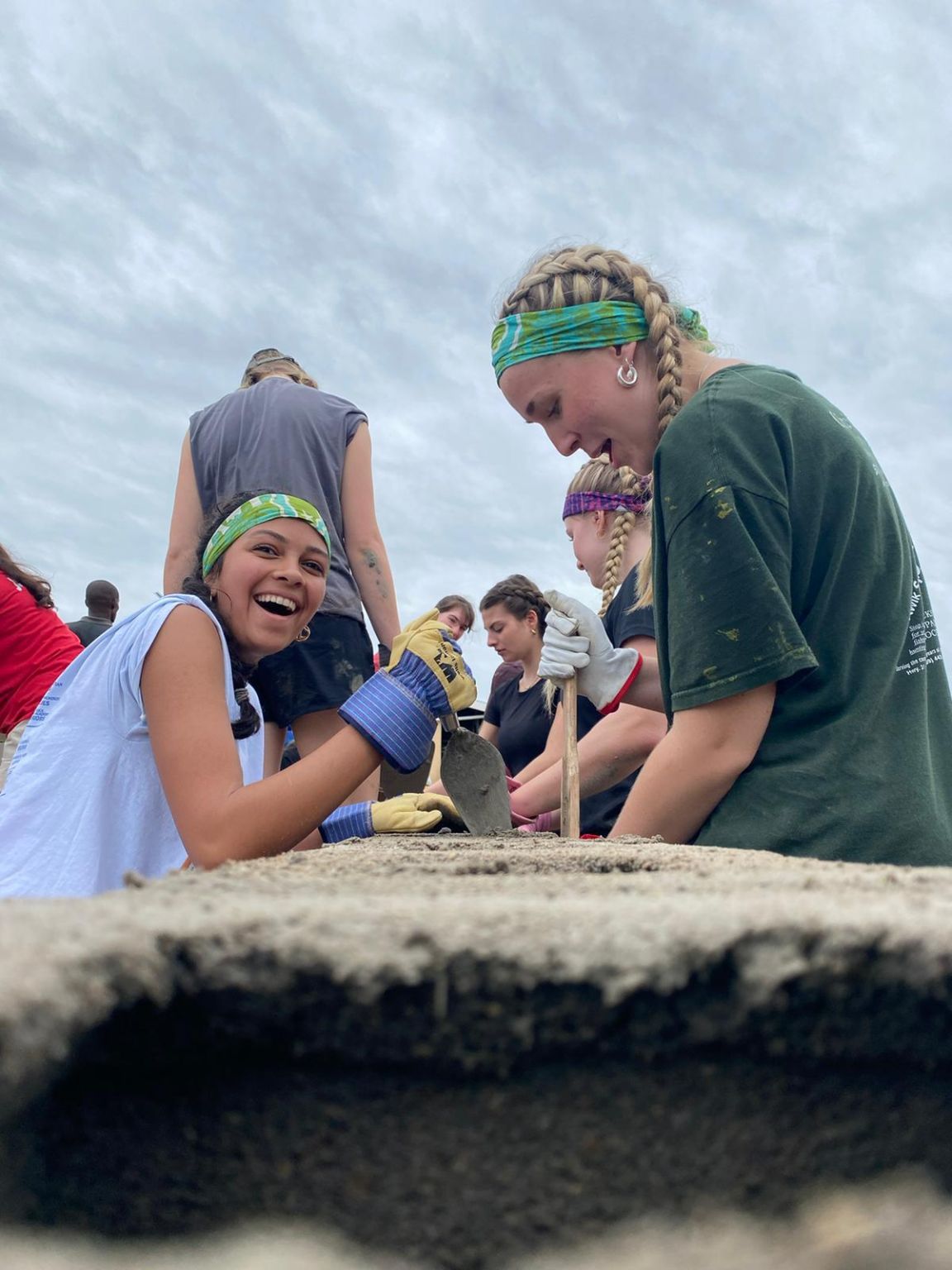 Students smiling as they work during service trip to build schools
