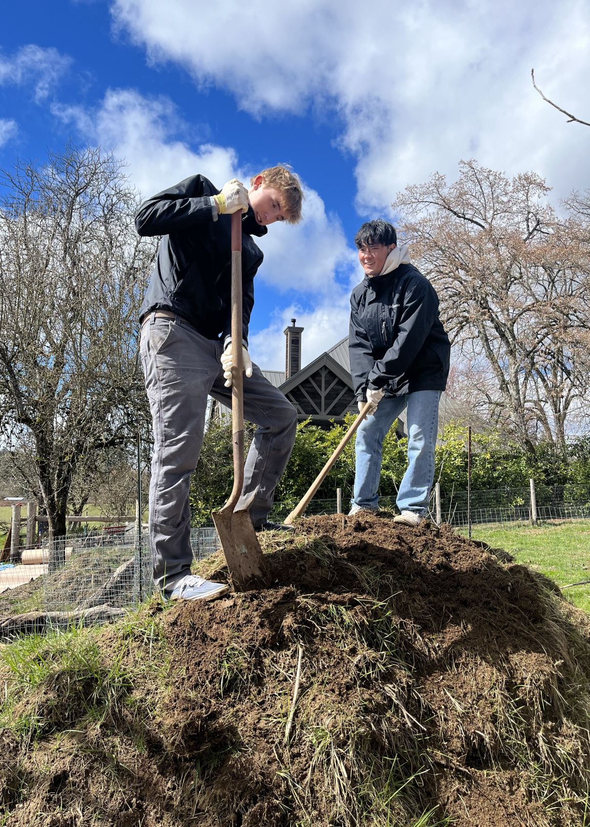 Two boys using tools to clean yard waste for Brentwood Service Day