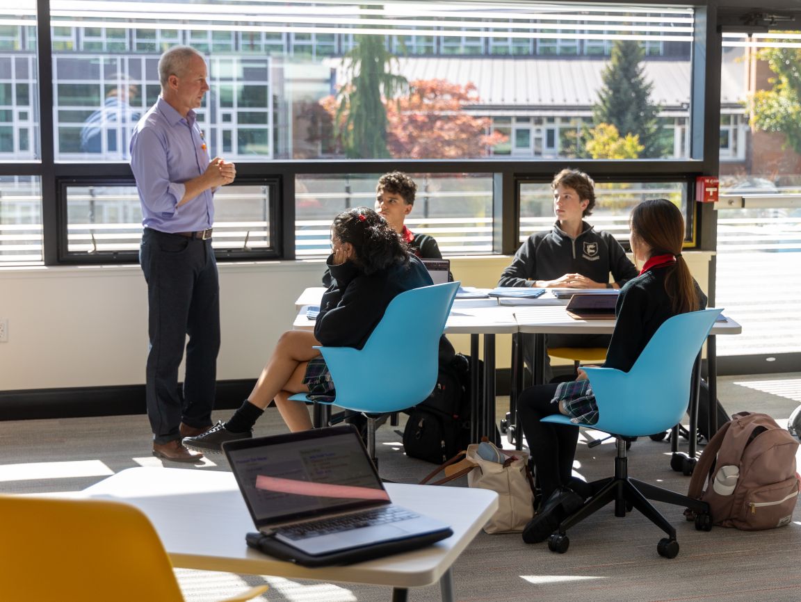 A teacher leading a small group of students in a classroom discussion