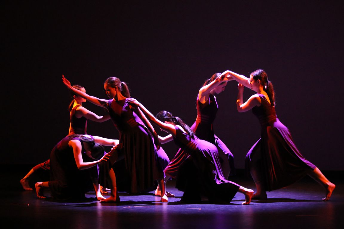 A group of students performing a modern dance on stage