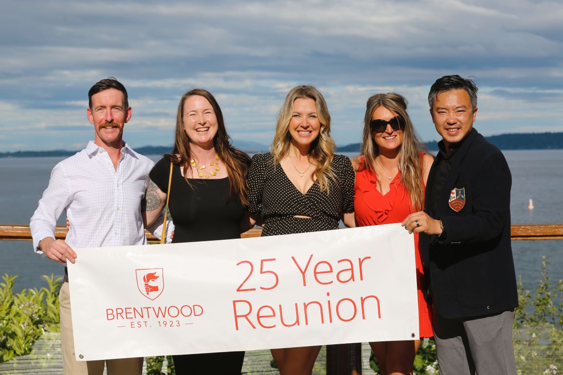 Alumni holding a 25 Year Reunion banner at the 2024 Centenary celebration