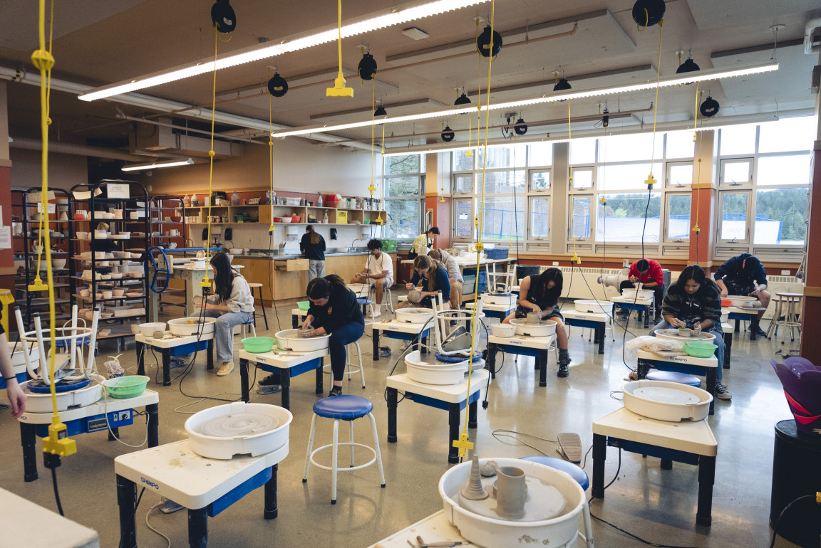 Students working at pottery wheels in the ceramics studio