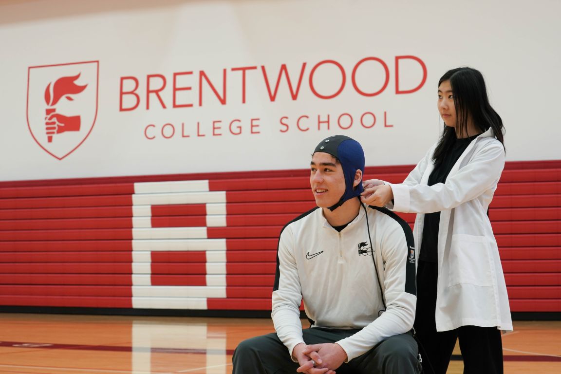 NeuroCatch cap on student athlete with student scientist assisting