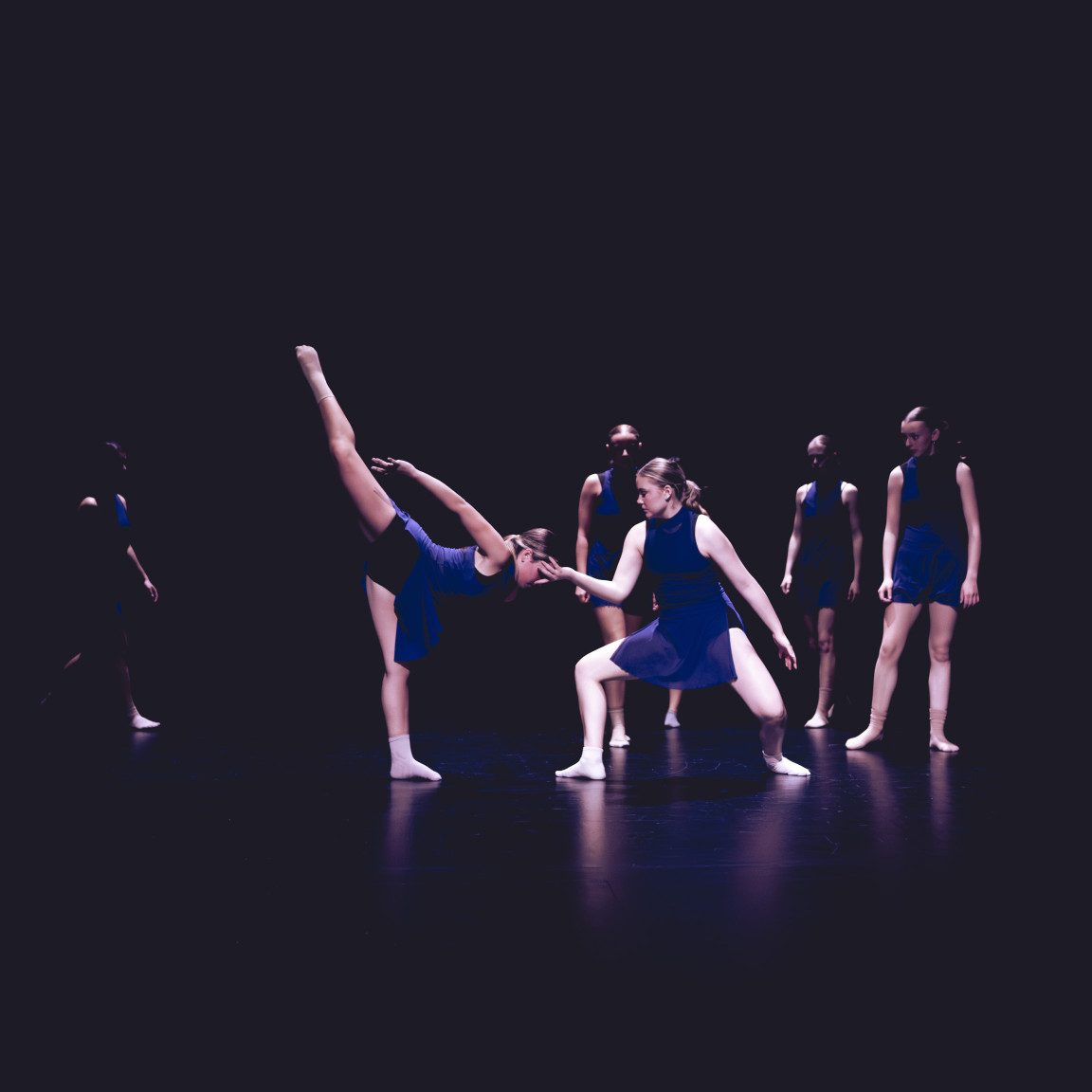 Students performing contemporary dance on stage during an arts class