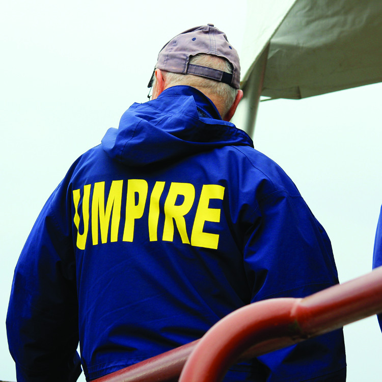 A regatta umpire wearing a blue Umpire jacket