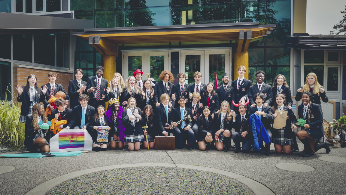 A large group of students dressed up posing together outside on campus