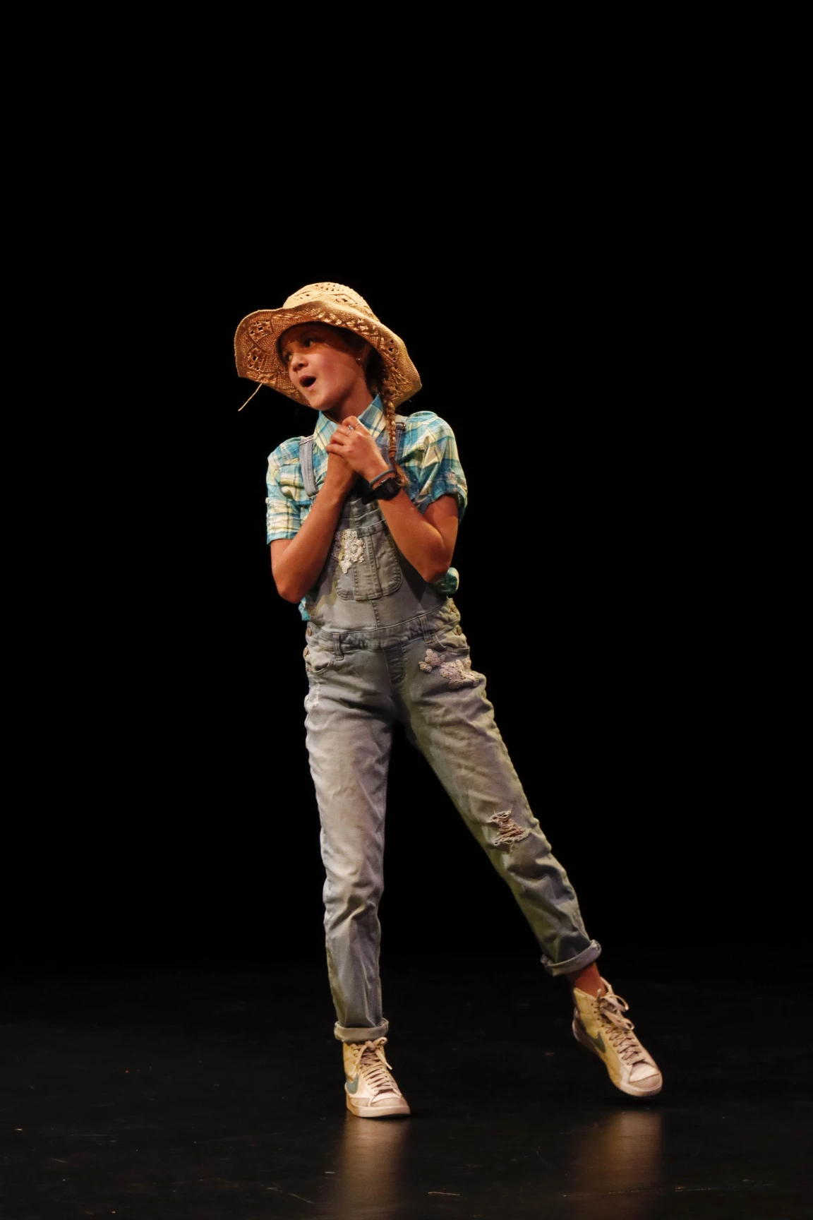 Young girl in costume singing on stage