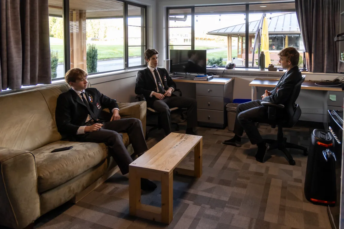 Students sitting and talking in a boarding house lounge
