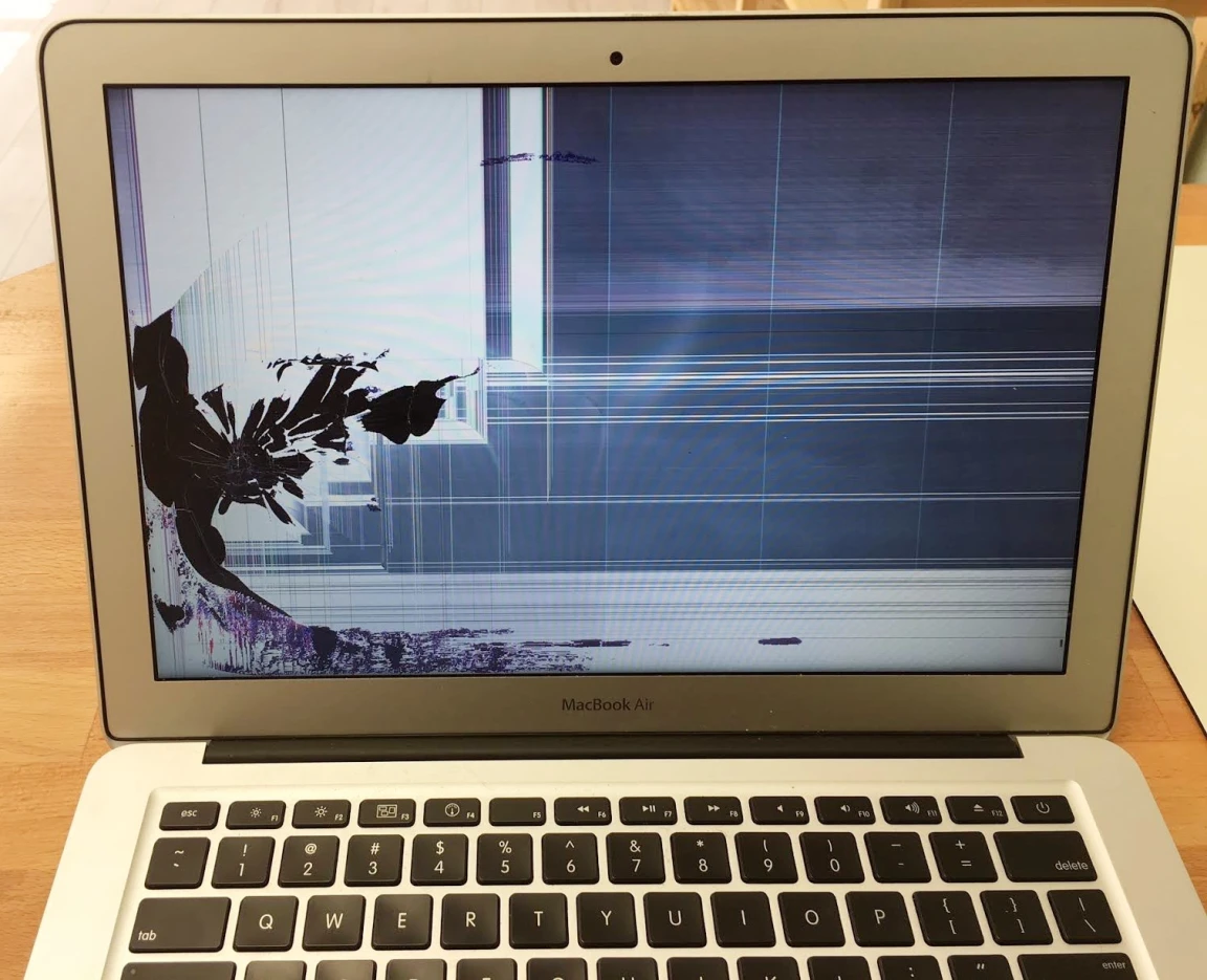 A laptop with a cracked, damaged screen