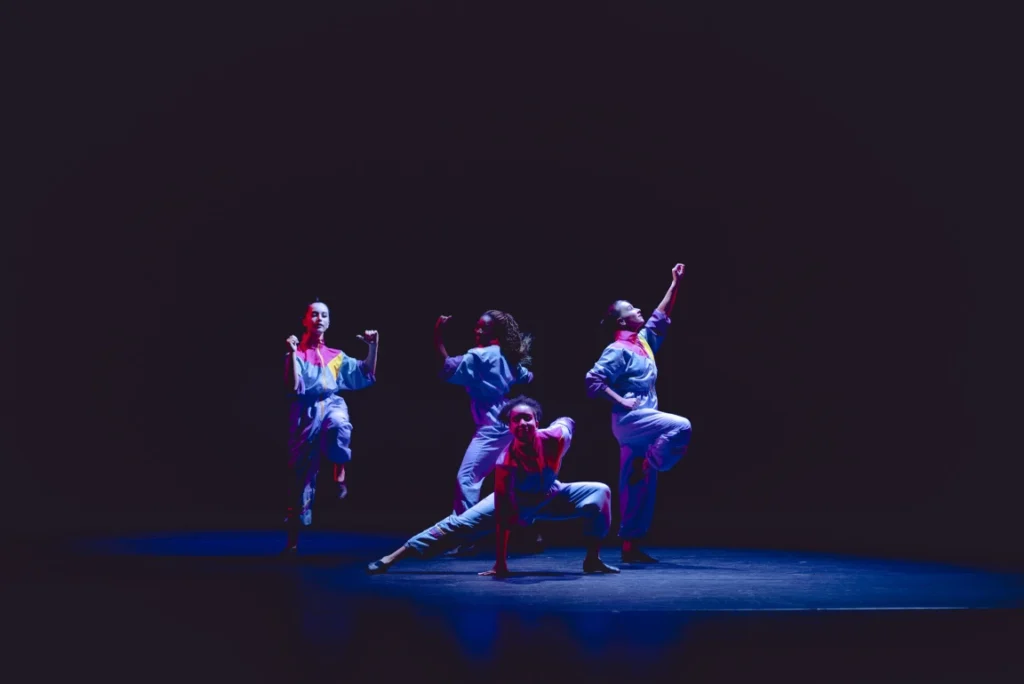 A quartet of students dancing on stage