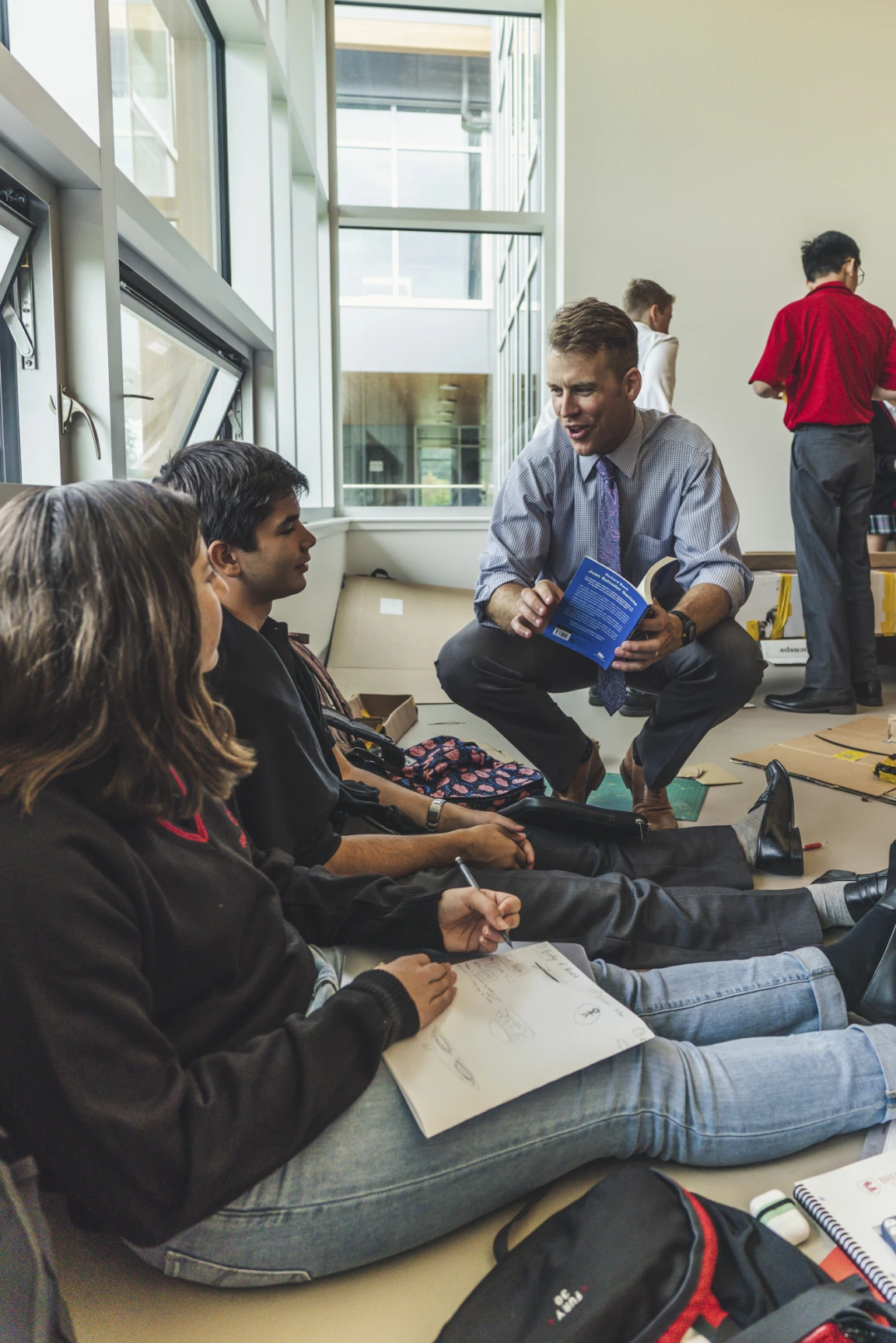 A boarding school teacher talking with two students
