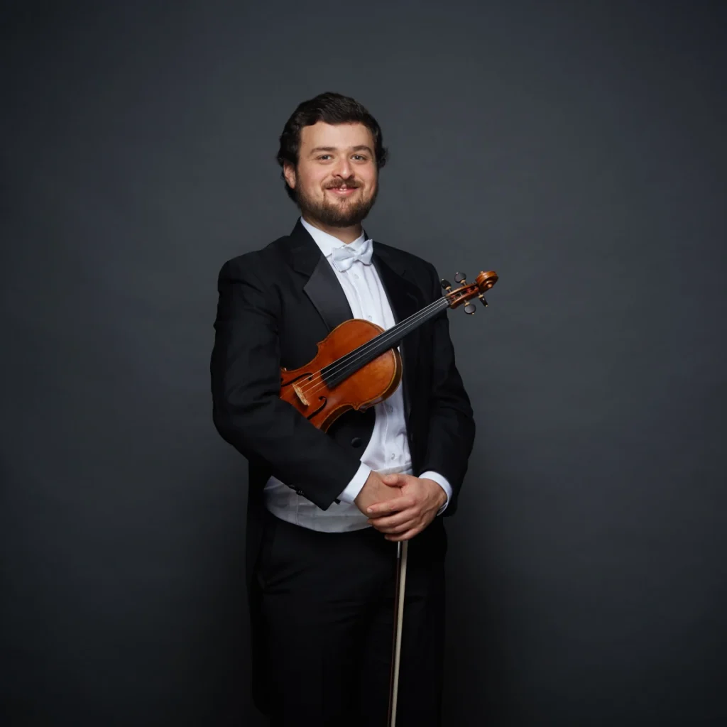 Operations and Program Director David Lakirovich, with violin and tuxedo