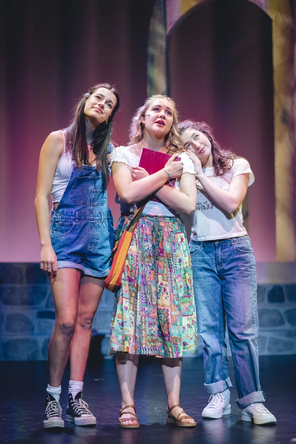Three students performing a scene from the musical Mamma Mia on stage