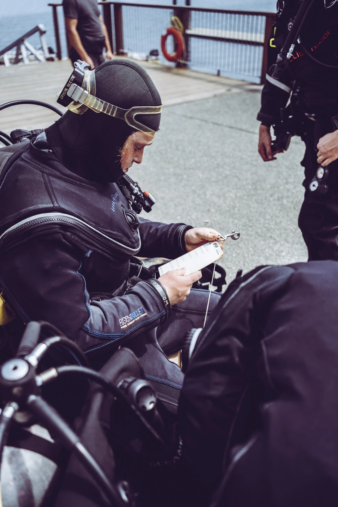 A student checking a list of diving items