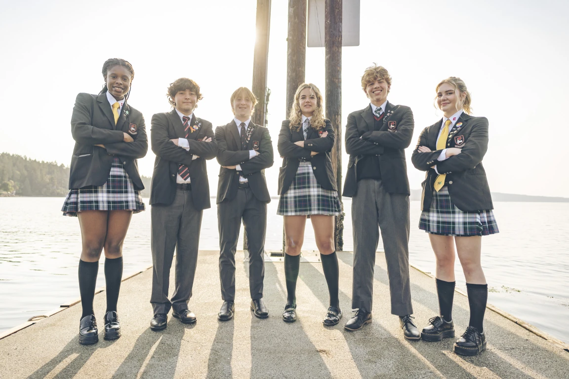Six boarding students crossing their arms while posing on the docks